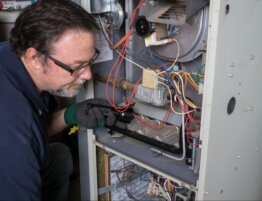 HVAC technician inspecting heating system components